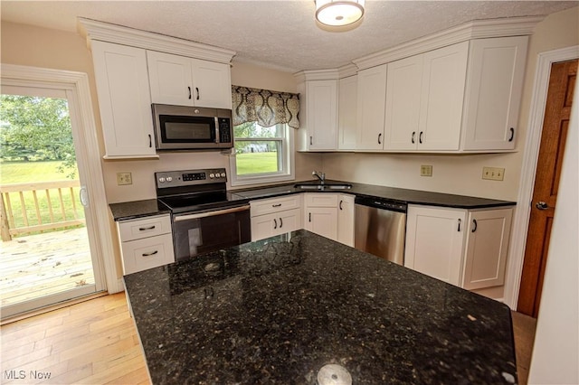 9306 Beech St, Louisville, OH 44641 - kitchen with appliances with stainless steel finishes, white cabinetry, plenty of natural light, and a textured ceiling