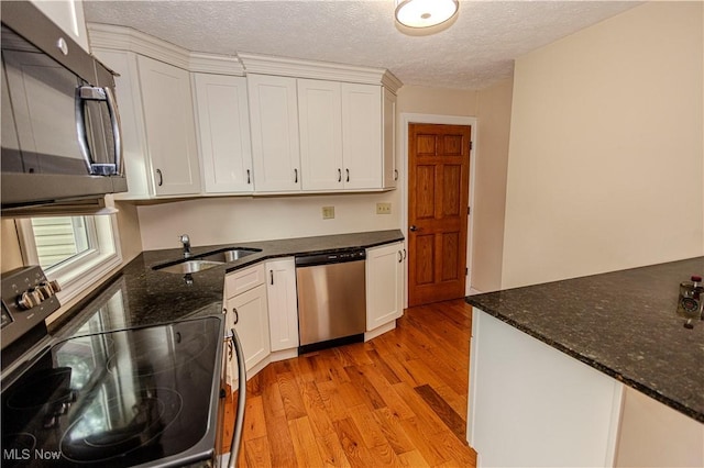 9306 Beech St, Louisville, OH 44641 - kitchen with black microwave, range with electric stovetop, dishwasher, light wood-style flooring, and white cabinetry