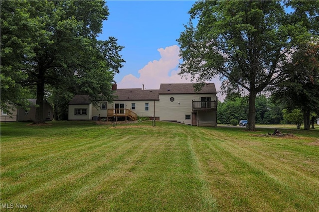 9306 Beech St, Louisville, OH 44641 - rear view of house featuring a lawn, a deck, and stairway