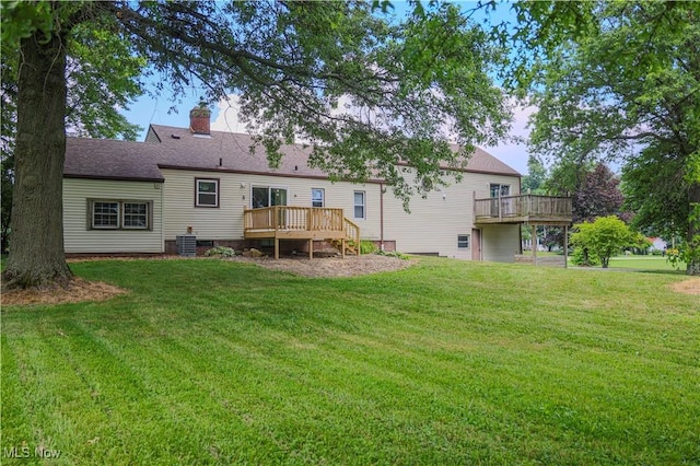 9306 Beech St, Louisville, OH 44641 - back of property featuring a wooden deck, a yard, and a chimney