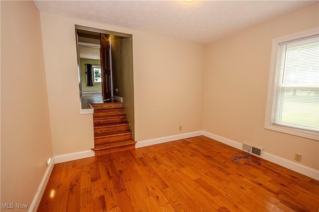 9306 Beech St, Louisville, OH 44641 - unfurnished room featuring wood finished floors, plenty of natural light, a textured ceiling, and stairs