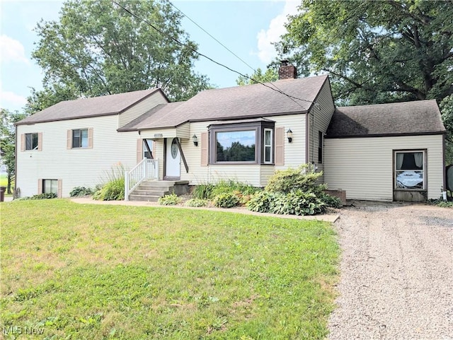 9306 Beech St, Louisville, OH 44641 - split level home with a chimney, driveway, a front yard, and roof with shingles