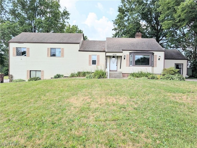 9306 Beech St, Louisville, OH 44641 - view of front of house with a front yard, a chimney, and a shingled roof