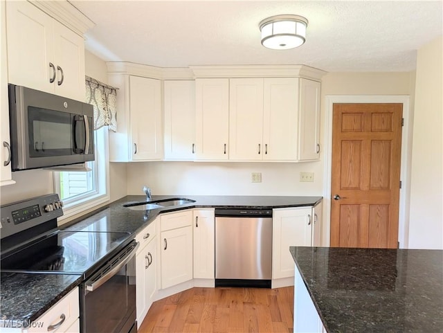 9306 Beech St, Louisville, OH 44641 - kitchen featuring stainless steel appliances, light wood-type flooring, white cabinets, and dark stone countertops