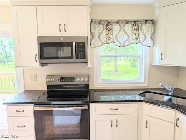 9306 Beech St, Louisville, OH 44641 - kitchen with appliances with stainless steel finishes, white cabinets, and dark stone counters