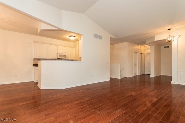 583 Mock Orange Cir, Chagrin Falls, OH 44023 - unfurnished living room with lofted ceiling, a chandelier, and dark wood-style floors
