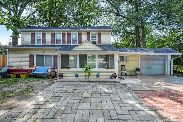 1552 E 254th St, Euclid, OH 44117 - view of front facade with decorative driveway, a garage, and roof with shingles