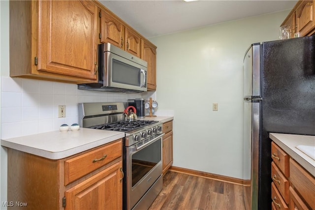 291 S Cleveland Ave, Mogadore, OH 44260 - kitchen featuring stainless steel appliances, dark wood-style floors, decorative backsplash, light countertops, and brown cabinets