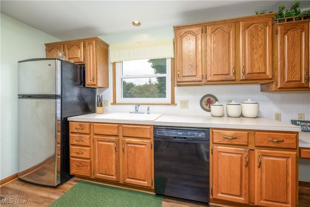 291 S Cleveland Ave, Mogadore, OH 44260 - kitchen featuring black dishwasher, freestanding refrigerator, light countertops, tasteful backsplash, and brown cabinets