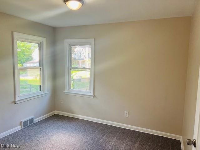 1700 Malasia Rd, Akron, OH 44305 - spare room featuring dark carpet and healthy amount of natural light