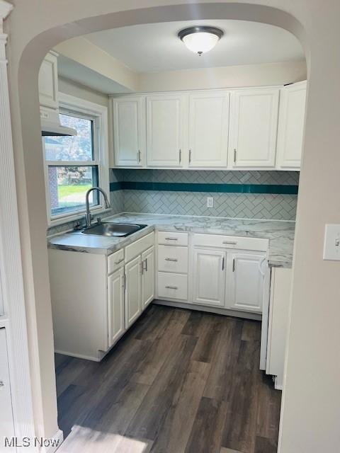 1700 Malasia Rd, Akron, OH 44305 - kitchen featuring dark wood-type flooring, white cabinets, backsplash, and arched walkways