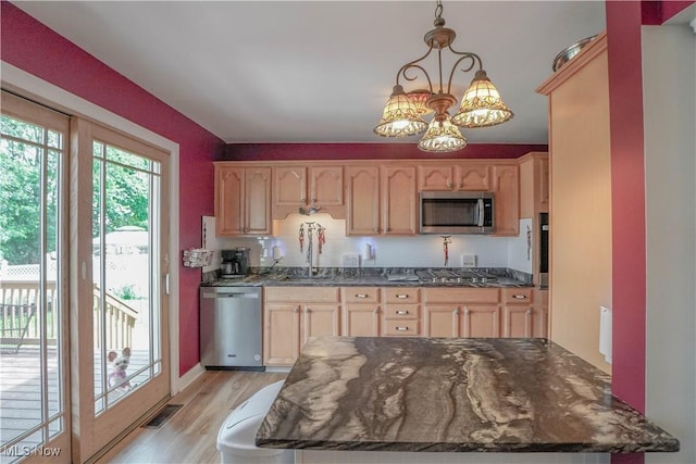 2077 Daniels Ave, Akron, OH 44312 - kitchen with appliances with stainless steel finishes, light brown cabinetry, a chandelier, and light wood-style flooring