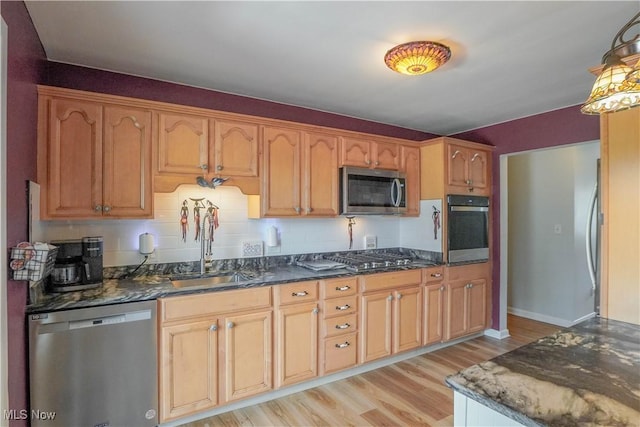 2077 Daniels Ave, Akron, OH 44312 - kitchen featuring appliances with stainless steel finishes, light wood-style floors, dark stone counters, and decorative light fixtures