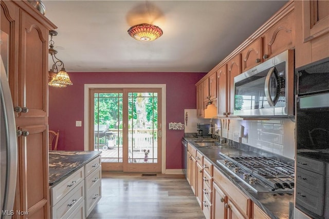 2077 Daniels Ave, Akron, OH 44312 - kitchen featuring stainless steel appliances, light wood-type flooring, decorative light fixtures, and brown cabinetry
