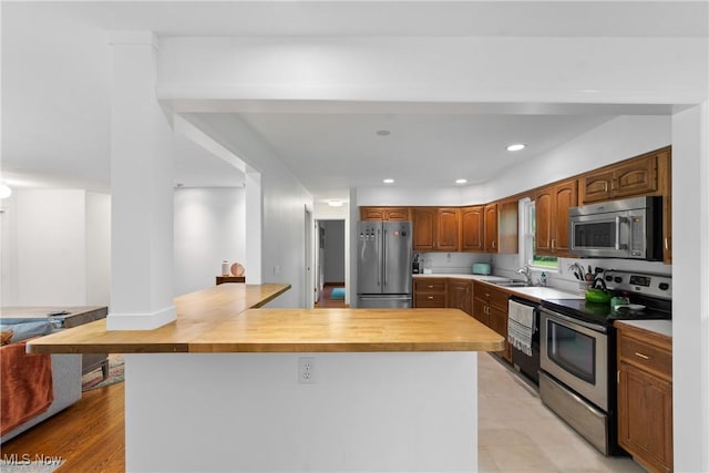 1332 Broadview Ave, Akron, OH 44321 - kitchen featuring stainless steel appliances, a peninsula, recessed lighting, and butcher block counters