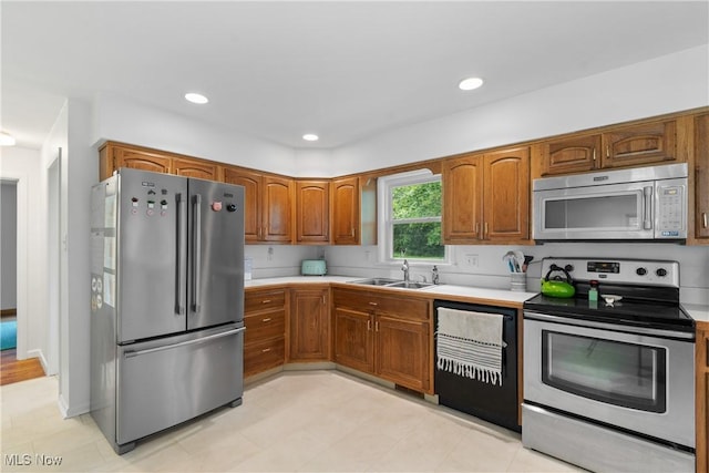 1332 Broadview Ave, Akron, OH 44321 - kitchen featuring appliances with stainless steel finishes, light countertops, brown cabinetry, and recessed lighting