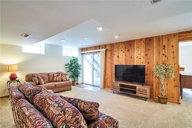 living room with carpet flooring, recessed lighting, and wood walls