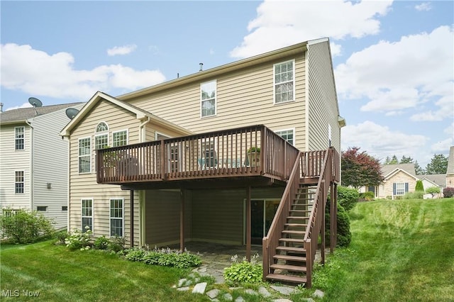 rear view of house with a wooden deck, stairs, and a lawn