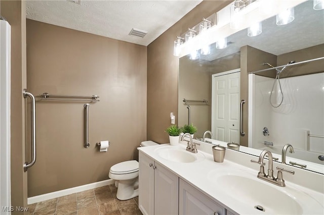 bathroom featuring double vanity, shower / bathtub combination, and a textured ceiling