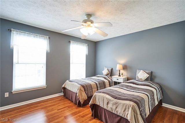 bedroom with wood finished floors, a textured ceiling, and ceiling fan