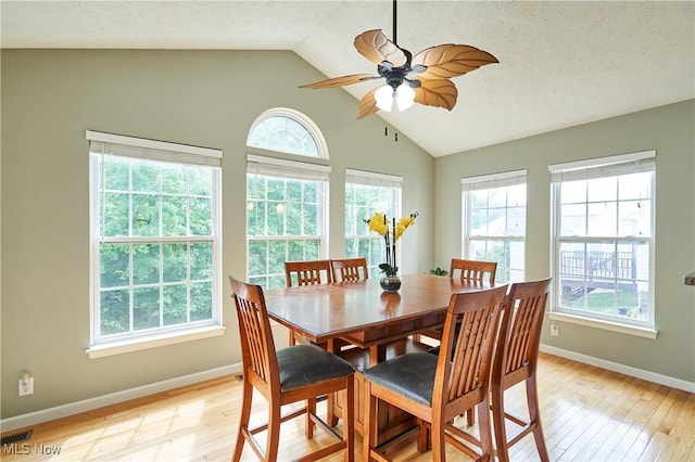dining room with plenty of natural light, lofted ceiling, light wood-type flooring, and a ceiling fan