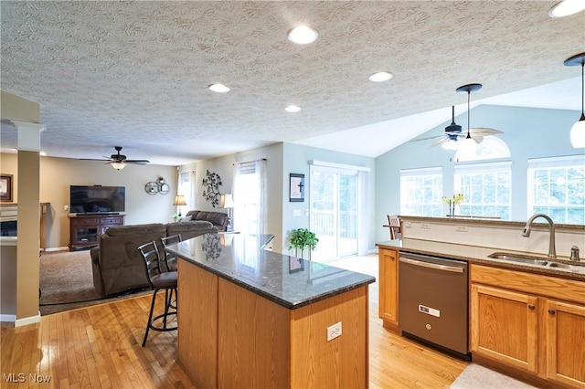 kitchen featuring dishwasher, ceiling fan, a center island, open floor plan, and lofted ceiling