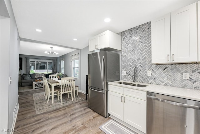 908 Dawnwood Dr, Parma, OH 44134 - kitchen with appliances with stainless steel finishes, light wood-type flooring, white cabinetry, decorative backsplash, and recessed lighting