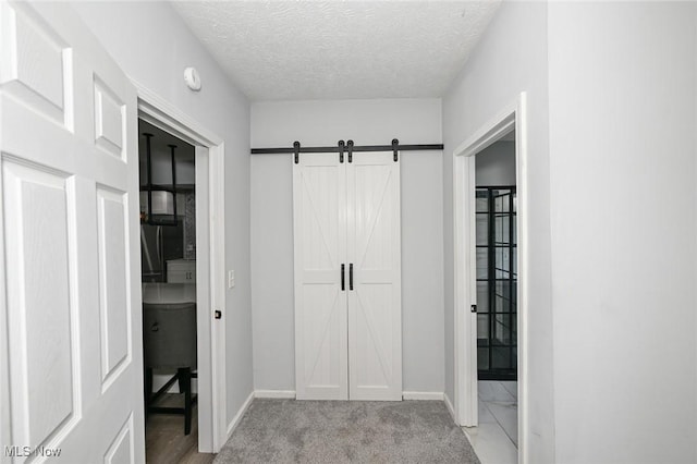 908 Dawnwood Dr, Parma, OH 44134 - hallway with a barn door, a textured ceiling, and light carpet