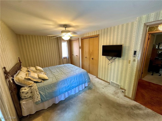 130 E 199th St, Euclid, OH 44119 - carpeted bedroom featuring wallpapered walls, a ceiling fan, and two closets
