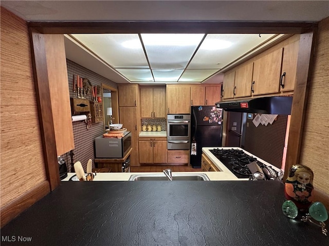130 E 199th St, Euclid, OH 44119 - kitchen with a warming drawer, stainless steel appliances, under cabinet range hood, and brown cabinets