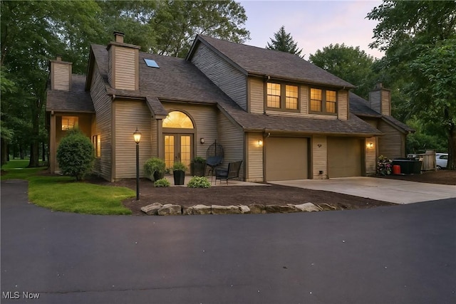 1293 Redtail Hawk Dr Unit 4, Boardman, OH 44512 - view of front of house featuring french doors, a chimney, an attached garage, and concrete driveway