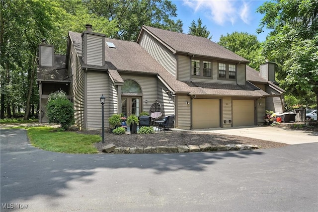 1293 Redtail Hawk Dr Unit 4, Boardman, OH 44512 - view of front of property with a chimney, an attached garage, driveway, roof with shingles, and french doors