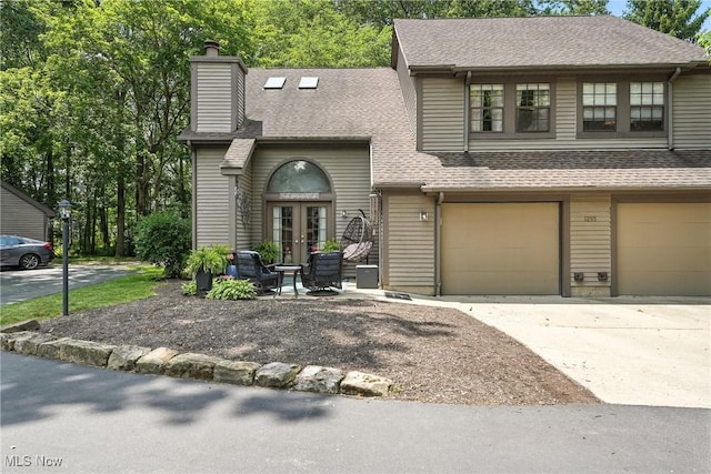 1293 Redtail Hawk Dr Unit 4, Boardman, OH 44512 - view of front of property with french doors, concrete driveway, a garage, a chimney, and roof with shingles