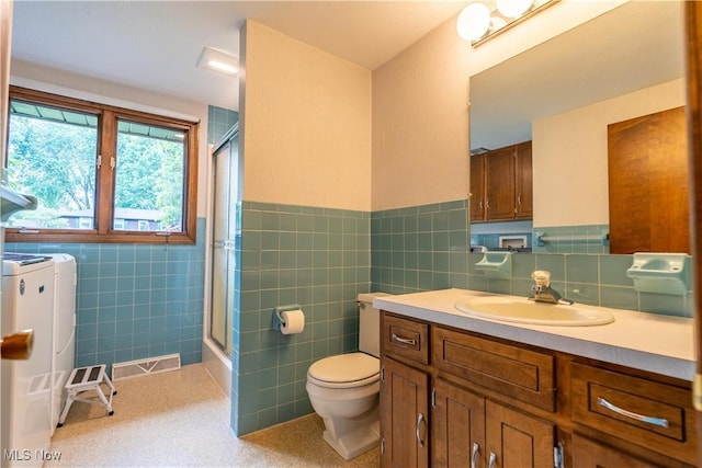 5200 Tanglewood Ave NE, Louisville, OH 44641 - bathroom featuring tile walls, washer and dryer, an enclosed shower, vanity, and wainscoting