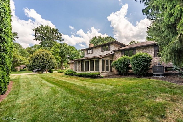 5200 Tanglewood Ave NE, Louisville, OH 44641 - rear view of house featuring a chimney, a yard, and a sunroom