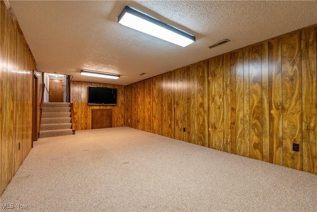 5200 Tanglewood Ave NE, Louisville, OH 44641 - finished below grade area featuring a textured ceiling, carpet, wooden walls, and stairway