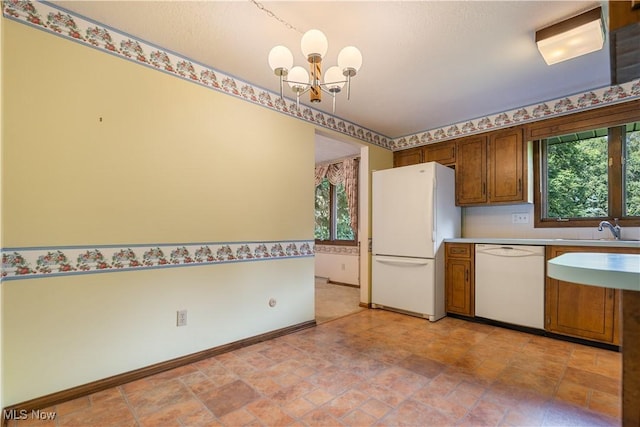 5200 Tanglewood Ave NE, Louisville, OH 44641 - kitchen with white appliances, a chandelier, brown cabinetry, light countertops, and light stone finish flooring