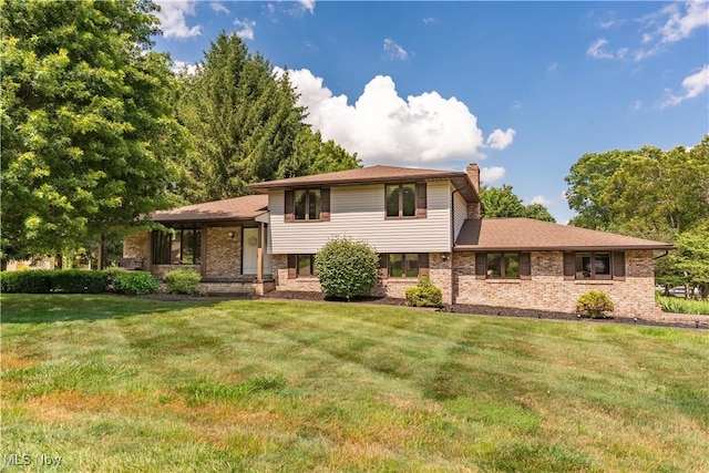 5200 Tanglewood Ave NE, Louisville, OH 44641 - split level home featuring a chimney, a front yard, and brick siding