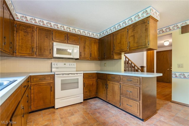 5200 Tanglewood Ave NE, Louisville, OH 44641 - kitchen featuring white appliances, light countertops, a peninsula, brown cabinets, and light stone finish flooring