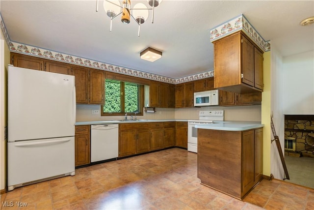 5200 Tanglewood Ave NE, Louisville, OH 44641 - kitchen featuring white appliances, light countertops, a chandelier, stone finish flooring, and a peninsula