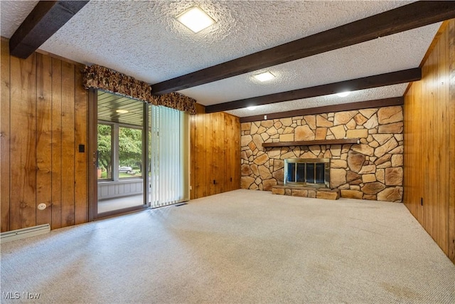 5200 Tanglewood Ave NE, Louisville, OH 44641 - unfurnished living room with wood walls, carpet flooring, beam ceiling, a textured ceiling, and a fireplace