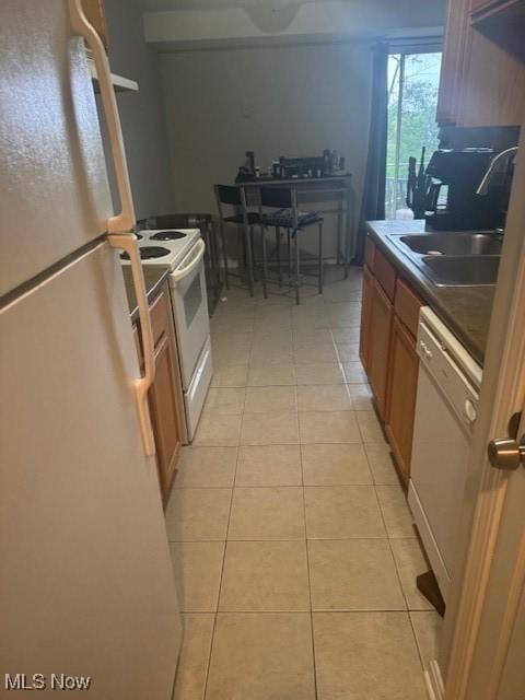 4383 Inner Circle Dr Unit B22, Brunswick, OH 44212 - kitchen with white appliances, light tile patterned floors, dark countertops, and brown cabinets