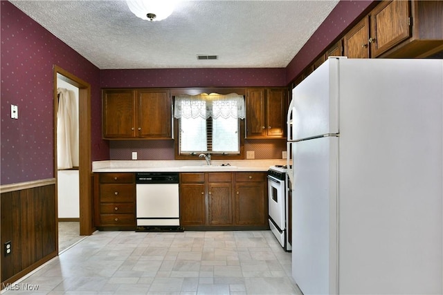 894 Pearson Cir Unit 3, Boardman, OH 44512 - kitchen featuring white appliances, wallpapered walls, a textured ceiling, wainscoting, and light countertops