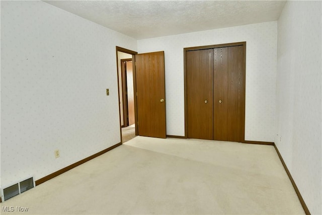 894 Pearson Cir Unit 3, Boardman, OH 44512 - unfurnished bedroom with light carpet, wallpapered walls, and a closet