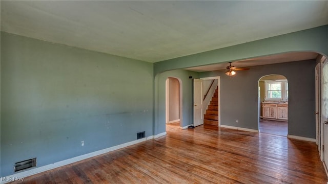60 S Liberty St, New Concord, OH 43762 - unfurnished room featuring arched walkways, stairs, wood finished floors, and ceiling fan