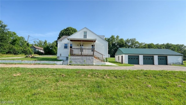 60 S Liberty St, New Concord, OH 43762 - bungalow featuring covered porch, a detached garage, an outdoor structure, and a front yard