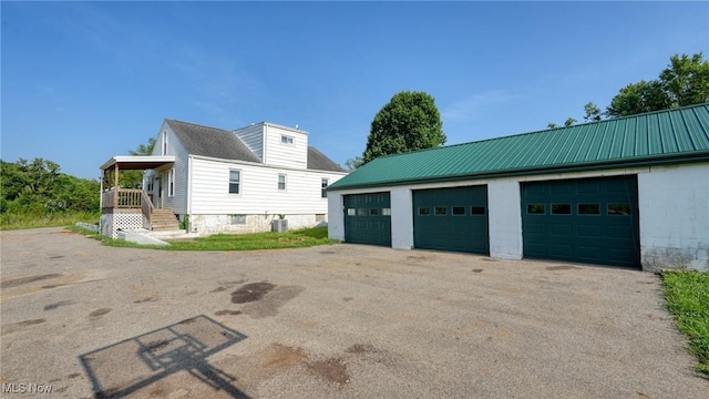 60 S Liberty St, New Concord, OH 43762 - view of property exterior featuring a metal roof, a garage, and an outbuilding