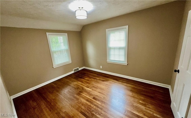 16721 Lomond Blvd, Shaker Heights, OH 44120 - unfurnished room featuring dark wood-style floors, lofted ceiling, and a textured ceiling