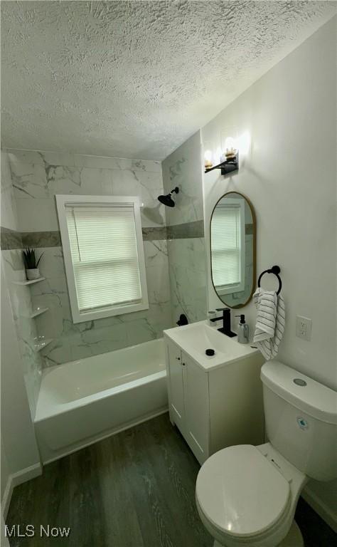 16721 Lomond Blvd, Shaker Heights, OH 44120 - bathroom with a textured ceiling, vanity, wood finished floors, and washtub / shower combination