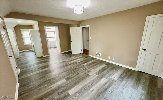 16721 Lomond Blvd, Shaker Heights, OH 44120 - unfurnished bedroom featuring dark wood finished floors, a textured ceiling, and ensuite bath